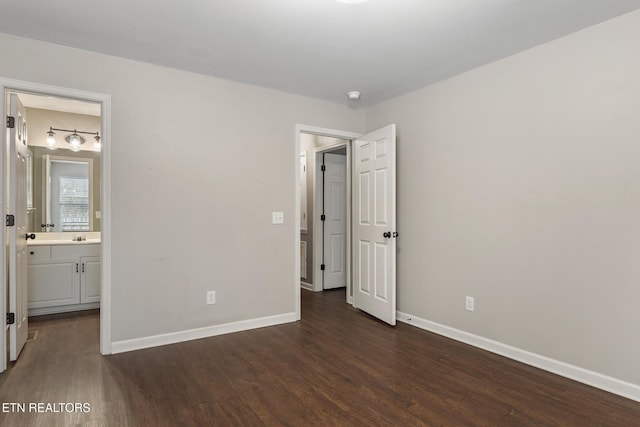 unfurnished bedroom featuring connected bathroom and dark hardwood / wood-style flooring