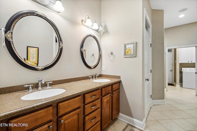 bathroom with vanity, washer / dryer, and tile patterned flooring