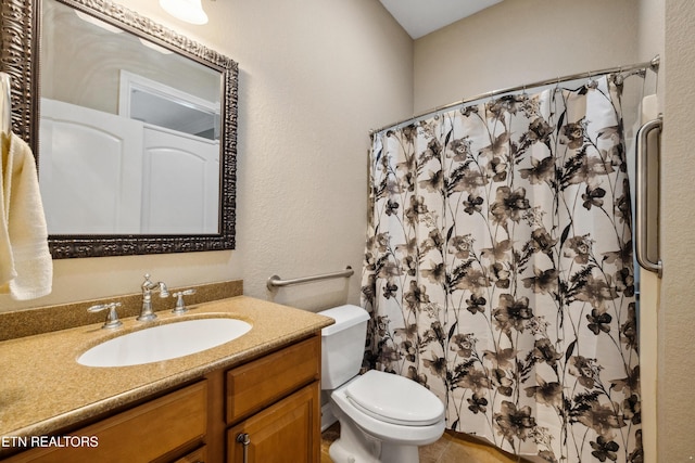 bathroom with curtained shower, toilet, and vanity