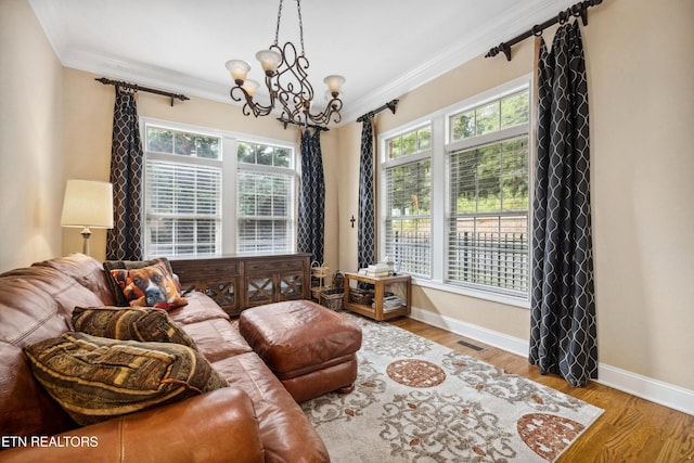 living room with wood-type flooring, a chandelier, and ornamental molding