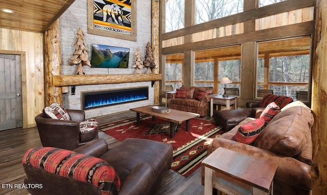 living room with wood ceiling, dark hardwood / wood-style flooring, wooden walls, a fireplace, and high vaulted ceiling