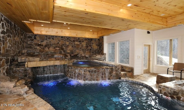 view of pool featuring pool water feature and an indoor hot tub