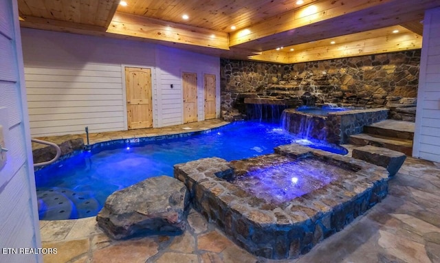 view of swimming pool featuring an in ground hot tub and pool water feature