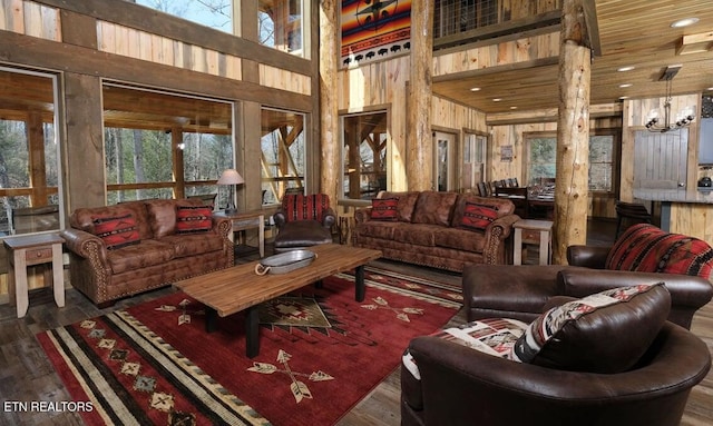 living room with wooden ceiling, a towering ceiling, wood walls, and hardwood / wood-style floors