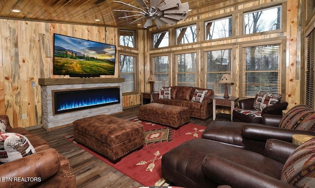 sunroom featuring ceiling fan, a fireplace, and wooden ceiling