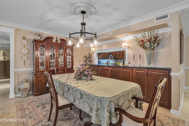 dining area with crown molding, sink, and a textured ceiling