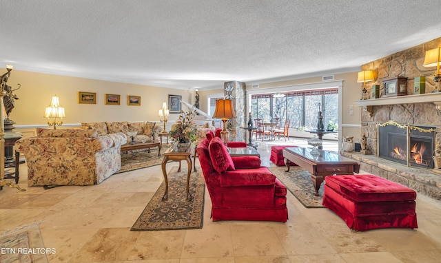 living room with a stone fireplace and a textured ceiling