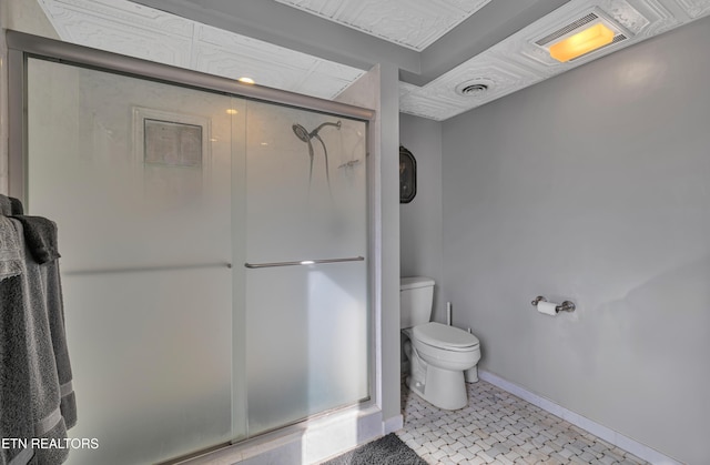 bathroom featuring toilet and a shower with shower door