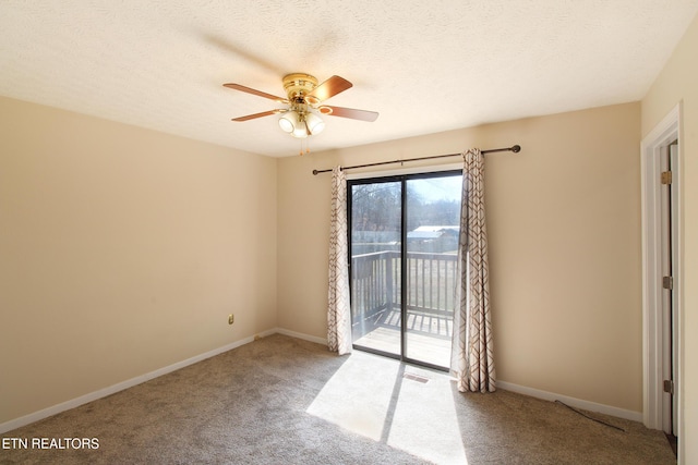 empty room featuring carpet floors, visible vents, ceiling fan, a textured ceiling, and baseboards