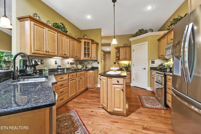 56 Westridge Ct, Fairfield Glade, TN 38558 - kitchen featuring stainless steel appliances, a sink, light wood-type flooring, tasteful backsplash, and a center island