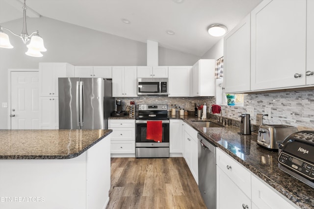 kitchen featuring vaulted ceiling, appliances with stainless steel finishes, sink, and white cabinetry