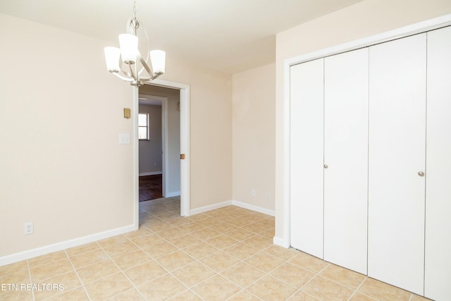 unfurnished bedroom featuring an inviting chandelier, a closet, and light tile patterned floors