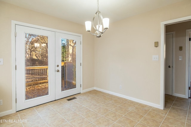 doorway featuring light tile patterned flooring, a chandelier, and french doors