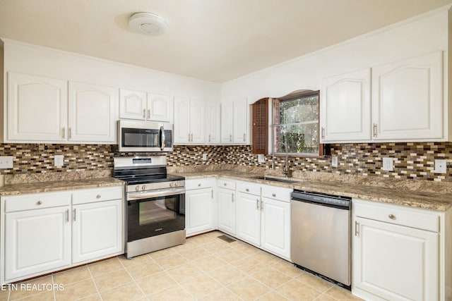 kitchen featuring sink, white cabinets, appliances with stainless steel finishes, and tasteful backsplash