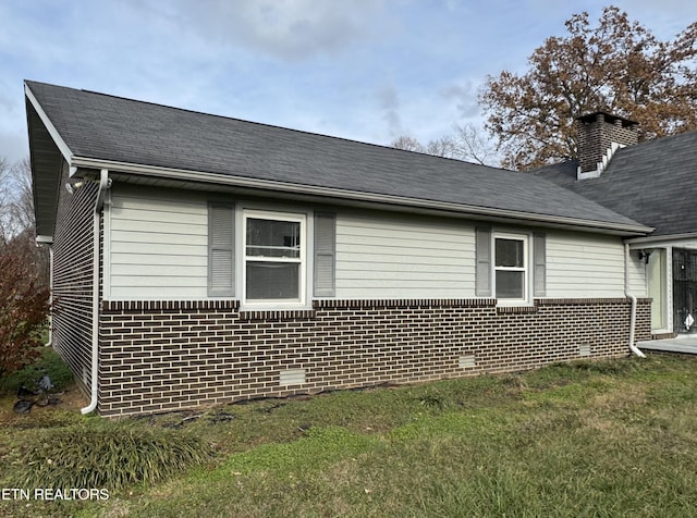 view of side of home with a yard