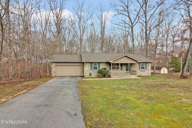 view of front of property with covered porch, a front yard, and a garage