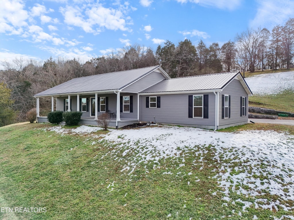 ranch-style house with a porch and a lawn