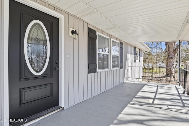 property entrance with covered porch and board and batten siding