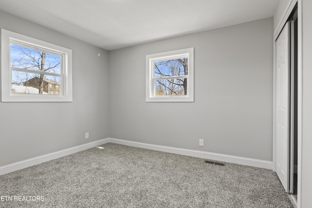 unfurnished bedroom with a closet, carpet flooring, visible vents, and baseboards