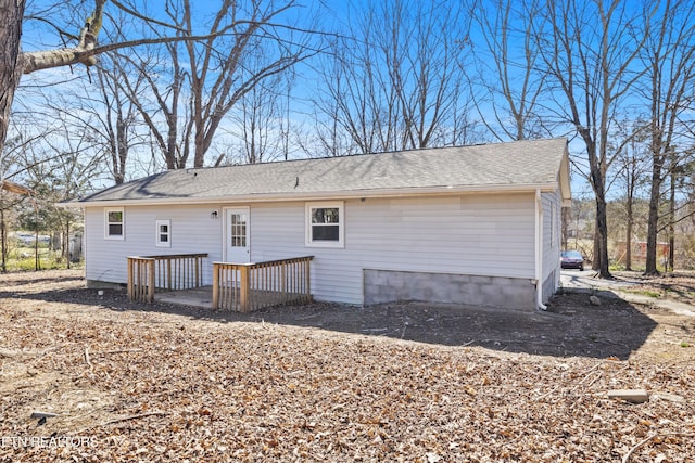 back of house with a shingled roof and a wooden deck