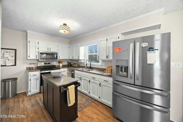 kitchen with sink, white cabinetry, stainless steel appliances, a textured ceiling, and dark hardwood / wood-style flooring