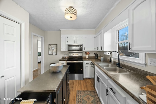 kitchen featuring white cabinets, appliances with stainless steel finishes, sink, and dark hardwood / wood-style flooring