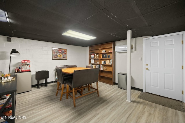 dining space featuring a wall mounted air conditioner and light wood-type flooring