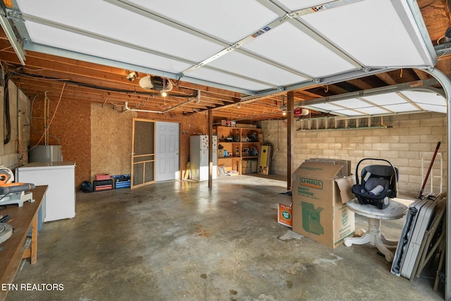 garage with white refrigerator, washer / dryer, and a garage door opener