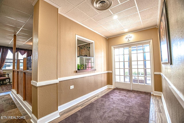 doorway with ornamental molding and dark hardwood / wood-style floors