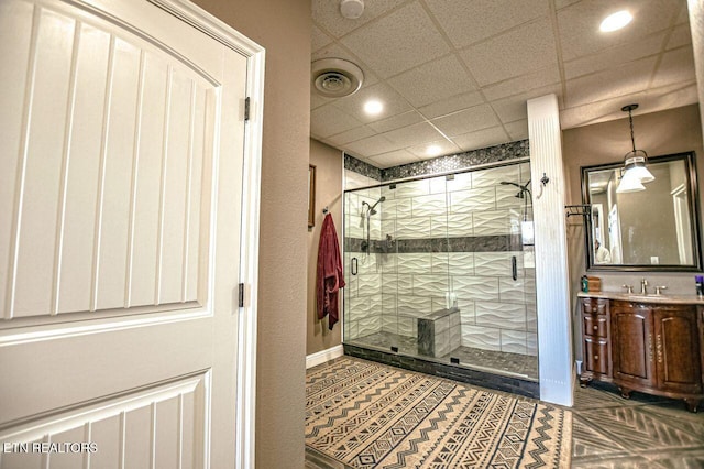 bathroom with vanity, a drop ceiling, and walk in shower