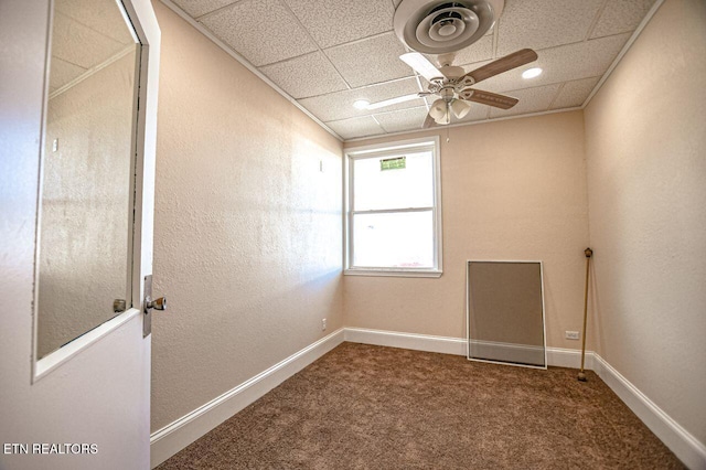 spare room with a paneled ceiling, ceiling fan, and carpet