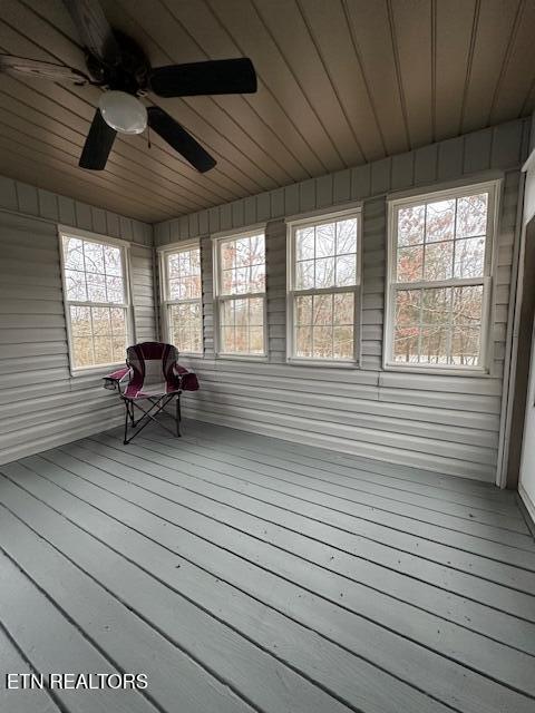 unfurnished sunroom with ceiling fan and wooden ceiling