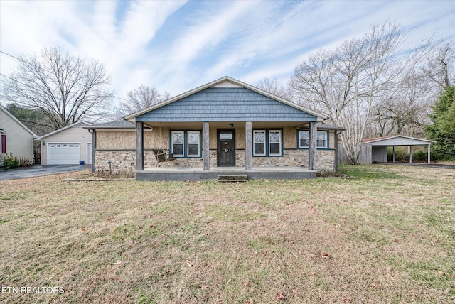 view of front of house with a carport, a garage, covered porch, and a front lawn