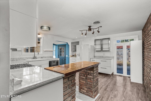 kitchen with sink, white cabinetry, black dishwasher, white refrigerator with ice dispenser, and light hardwood / wood-style floors