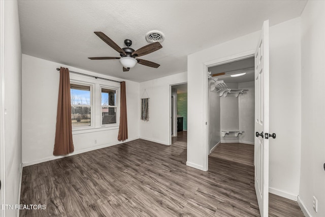 unfurnished bedroom featuring hardwood / wood-style flooring, ceiling fan, and a textured ceiling