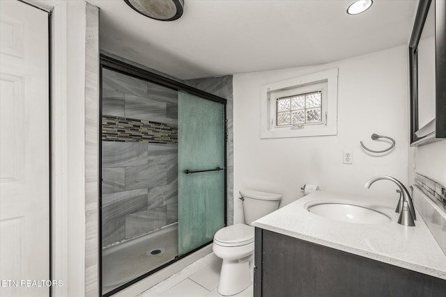 bathroom featuring vanity, a shower with door, and toilet