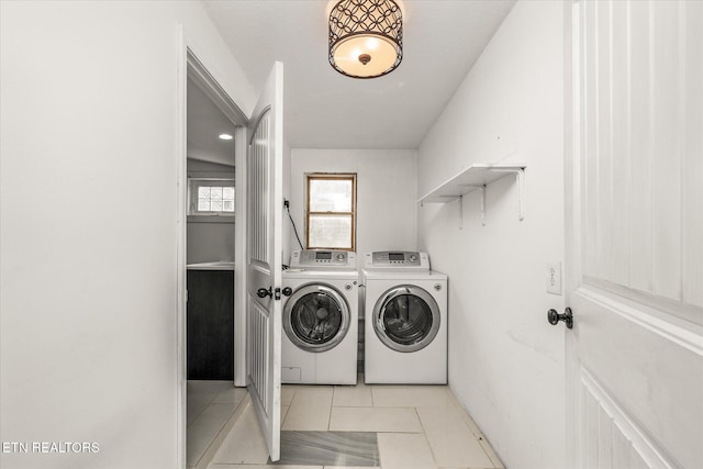 washroom with washer and clothes dryer and light tile patterned flooring