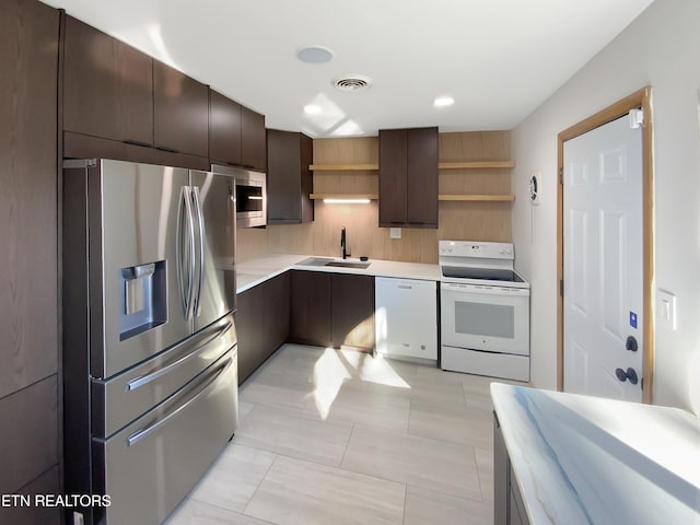 kitchen featuring sink, backsplash, dark brown cabinetry, and stainless steel appliances