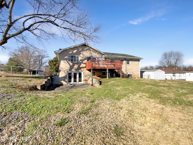 rear view of property with a wooden deck, a yard, and french doors