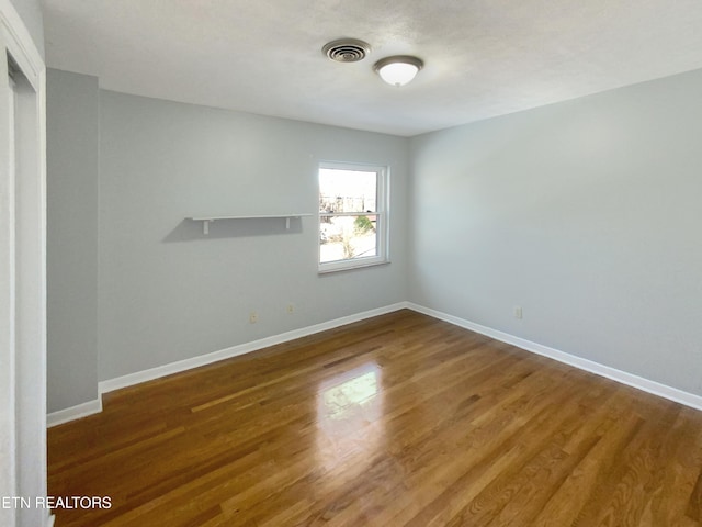 empty room with hardwood / wood-style flooring