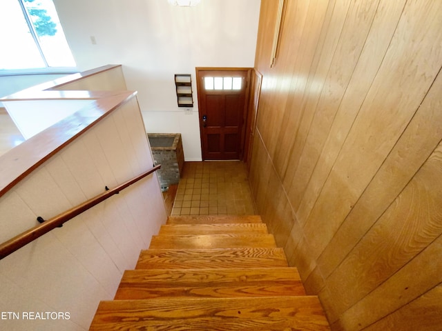 stairs with a healthy amount of sunlight and wooden walls