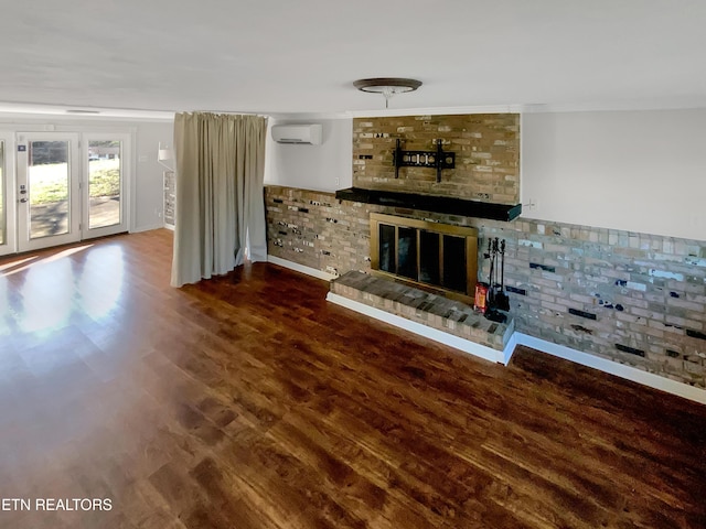 unfurnished living room featuring hardwood / wood-style flooring, a wall mounted air conditioner, crown molding, and a fireplace