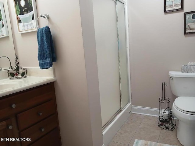 bathroom featuring toilet, tile patterned floors, a shower with shower door, and vanity