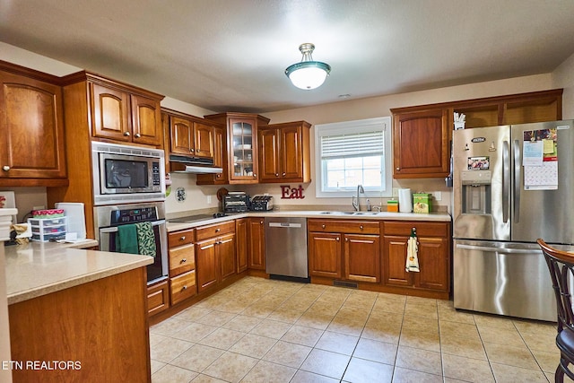 kitchen featuring light tile patterned flooring, stainless steel appliances, and sink