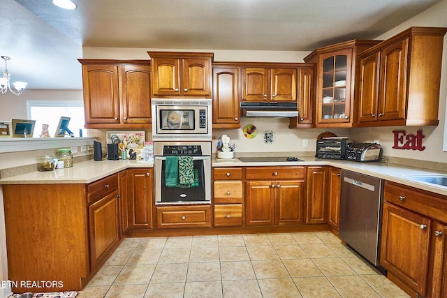 kitchen featuring light tile patterned flooring, appliances with stainless steel finishes, pendant lighting, and a notable chandelier