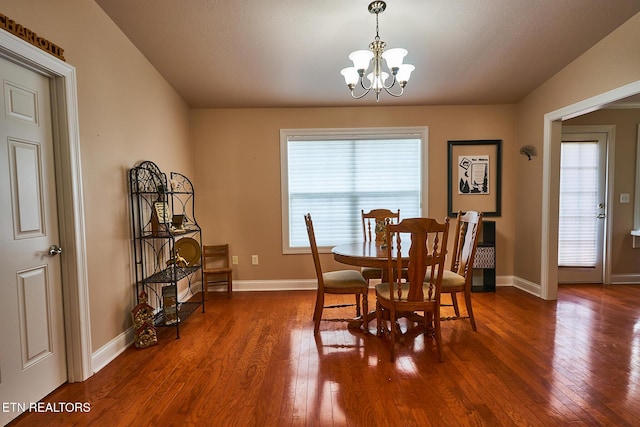 dining room with an inviting chandelier, plenty of natural light, and dark hardwood / wood-style floors