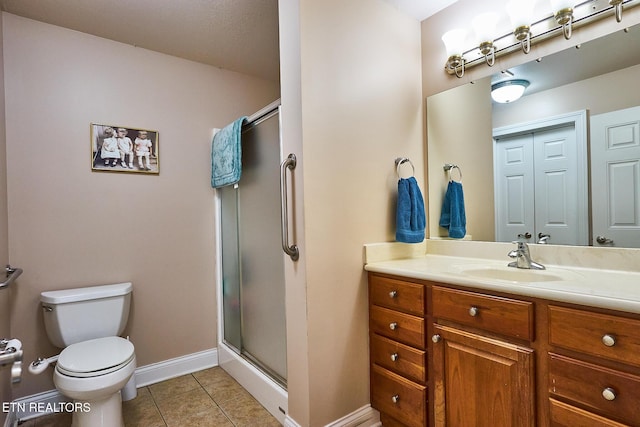 bathroom with tile patterned floors, toilet, vanity, and an enclosed shower