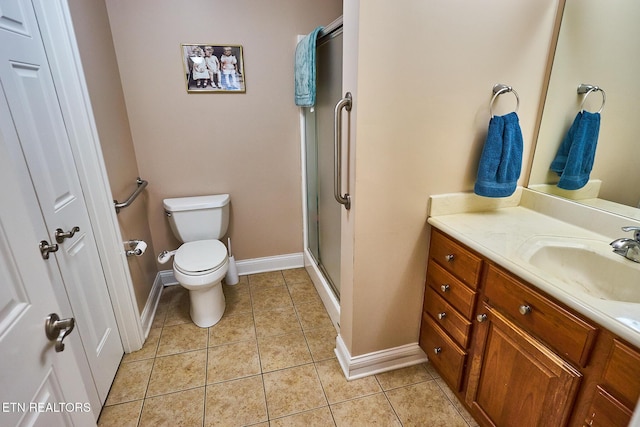 bathroom with tile patterned floors, walk in shower, vanity, and toilet