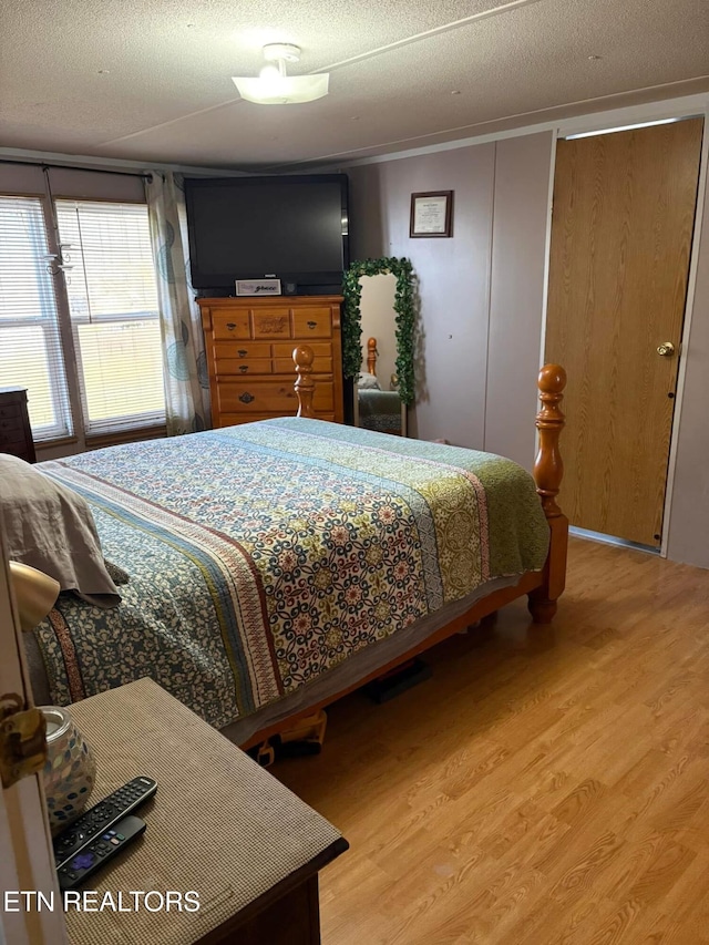 bedroom with a textured ceiling and hardwood / wood-style floors