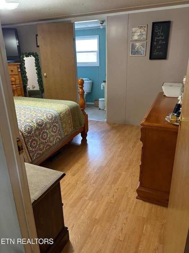 bedroom featuring light hardwood / wood-style floors and ensuite bath